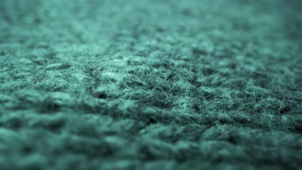 Extreme detail view of sheep wool cloth texture flowing in macro dolly shot. alt