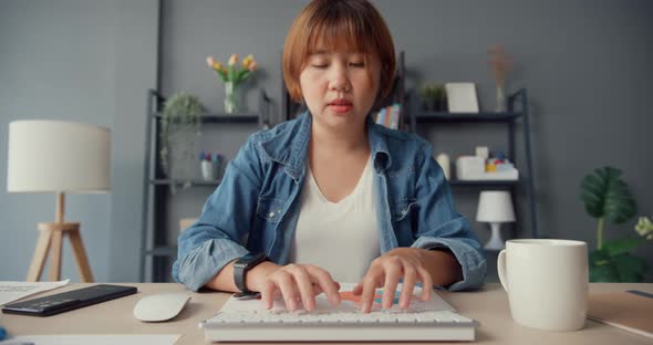 Asia lady casual wear using desktop computer online learn in living room at house.