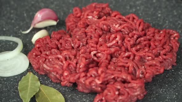 Fresh Ground Beef Rotates on Cutting Board with Onions