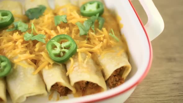 Chicken enchiladas with cheddar cheese and sauce. alt