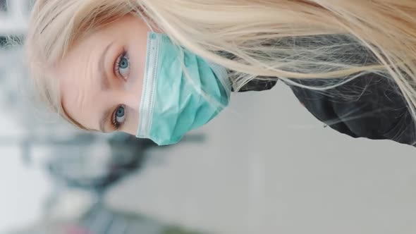 Young Blonde Woman in a Medical Mask Escaping From Somebody on the Street. alt