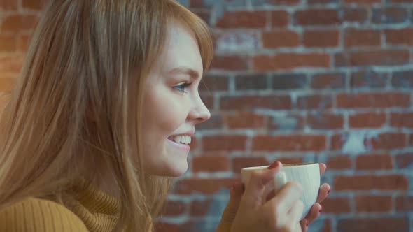 Beautiful girl is enjoying the aroma of coffee 