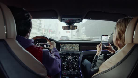 The driver drives the car, and the passenger takes pictures of the road.