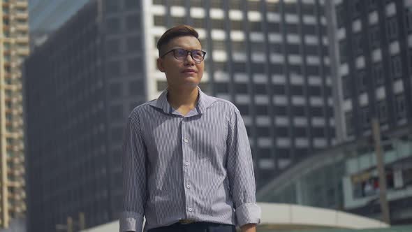 Portrait handsome businessman standing looking around the urban city.