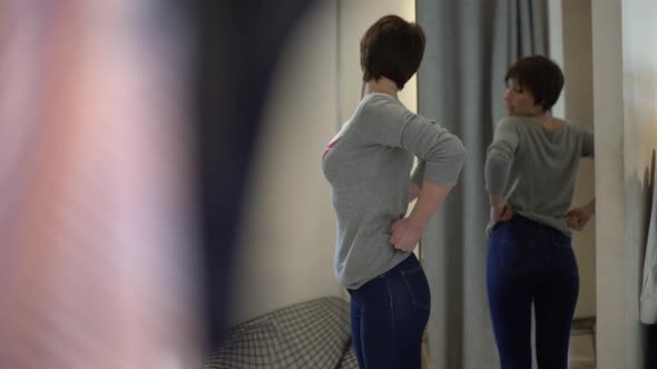 Woman trying on jeans in fitting room