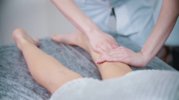 Massage - Massage Therapist Is Kneading the Legs of a Young Woman alt