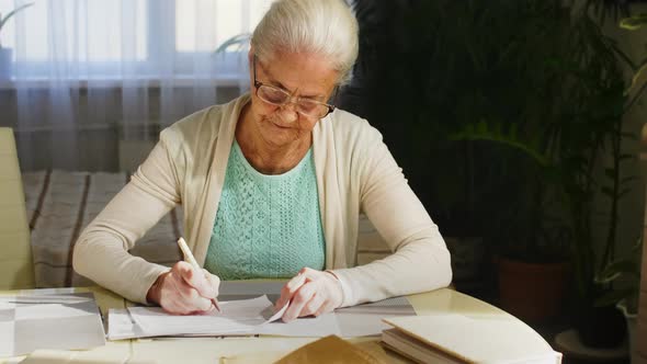 Senior Woman Signing Utility Bill