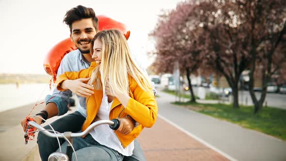 Young Loving Couple Dating While Riding Bicycles in the City
