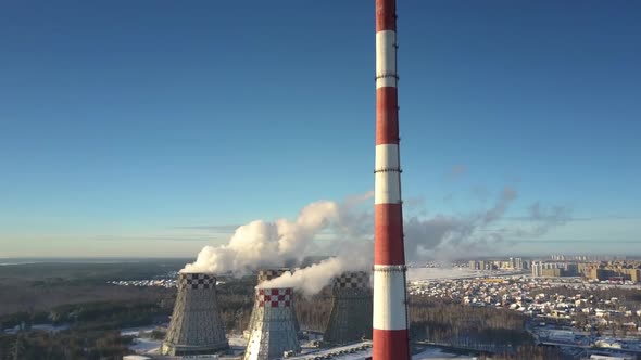 Aerial View Chimney and Cooling Towers Against Town and Sky alt