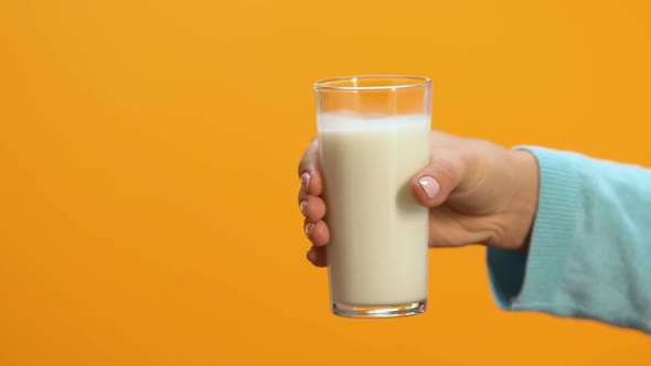 Lady Refusing Glass of Milk Offered by Person, Allergy and Lactose Intolerance alt
