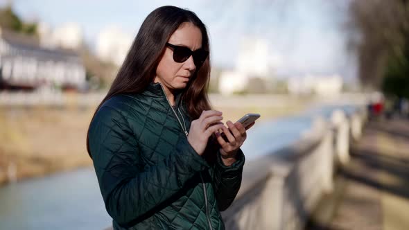 Closeup of an Adult Beautiful Woman a Student on the Street an Attractive Woman Holding a Smartphone alt