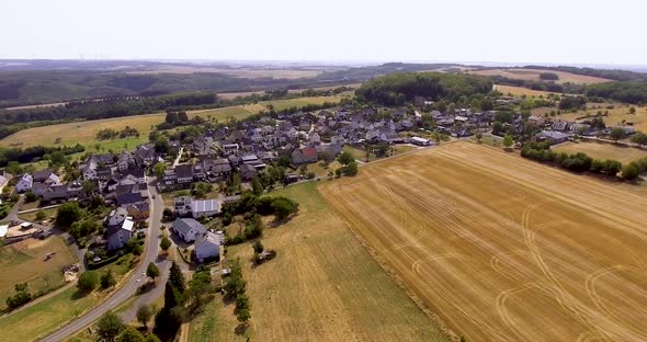 Flight with a DJI Phantom 4 Drone around a rural, german village located in rural, agricultural area alt