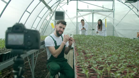 Young Farmer Recording Video in a Greenhouse