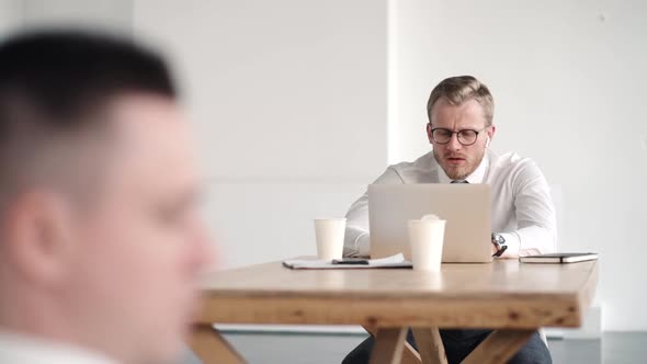 Caucasian Busy Men Talking in Shared Office, Male Colleagues in Coworking Atmosphere.