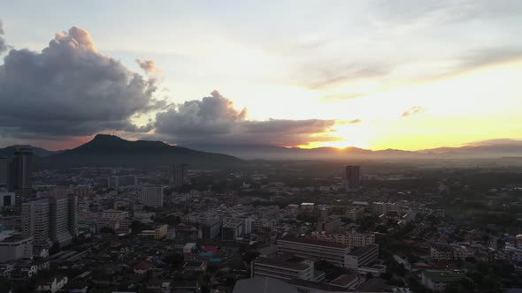 Aerial view drone moving slow motion scene of cityscape with sky sunrise over the mountain.