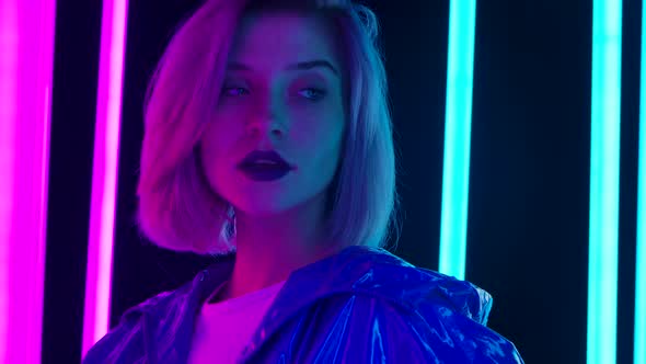 Portrait of a Young Stylish Sexual Blonde with Pink Short Hair Poses Against a Dark Studio alt