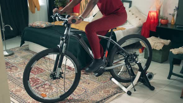 African-american Woman Is Training on an Exercycle at Home. Sport From Home, Fitness at Home. alt