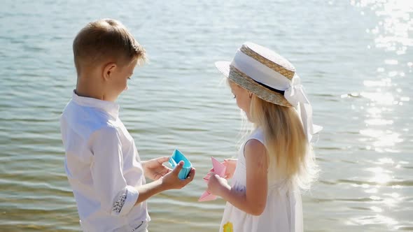 Boy gives flowers to girl, happy children, romantic gift to little girl, brother and sister alt