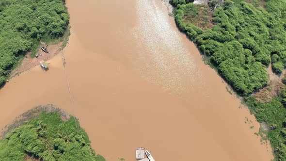High Top Down View Of The Lake From Two Floating Buildings to Beyond With Its Green Jungle Shoreline alt