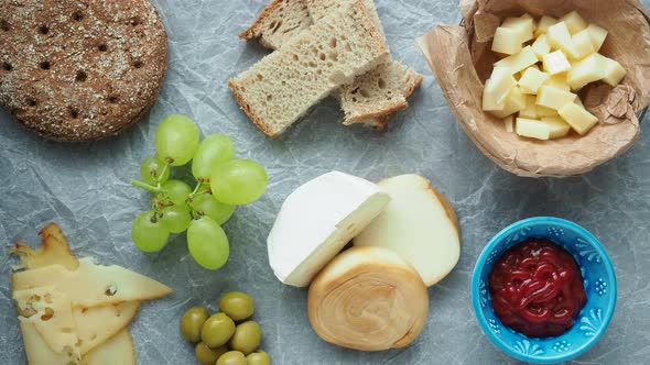 Cold appetizer. Cold cuts. Different snacks on a white crumpled paper, from above. 4k resolution