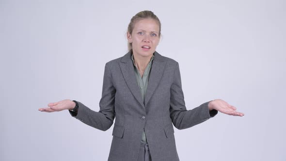 Young Confused Blonde Businesswoman Shrugging Shoulders alt