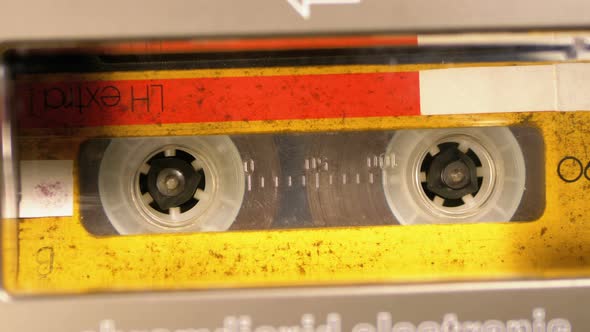 Vintage Yellow Audio Cassette in the Tape Recorder Playing and Rotates alt