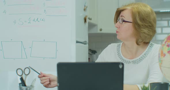 Serious Woman Is Talking By Video Call on tabletPC Teacher Is Communicating with Student Online alt