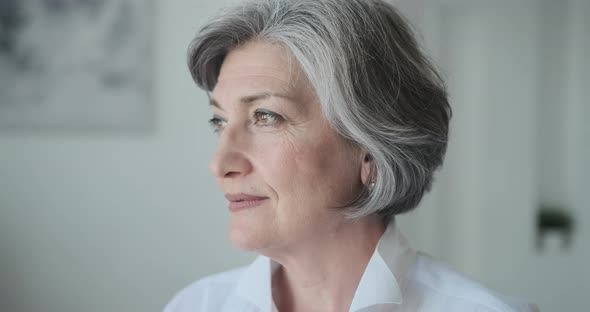 A Confident Educated Older Lady Executive Manager Stands in a Bright Contemporary Workplace and alt