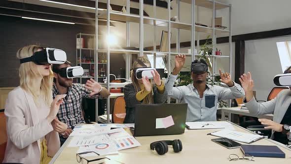 Diverse Group of Colleagues which Moving Hands on Virtual Screen Using Special 3d Glasses alt