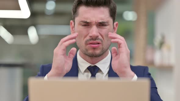 Close Up of Businessman with Laptop Having Headache alt