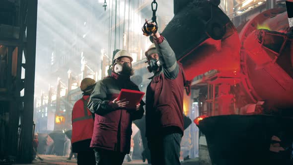 Steel Mill Workers are Talking While Wearing Respirators alt