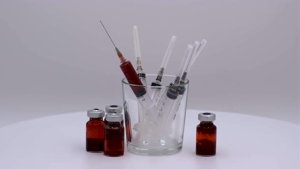 Vaccine bottle with red solution with syringe alt