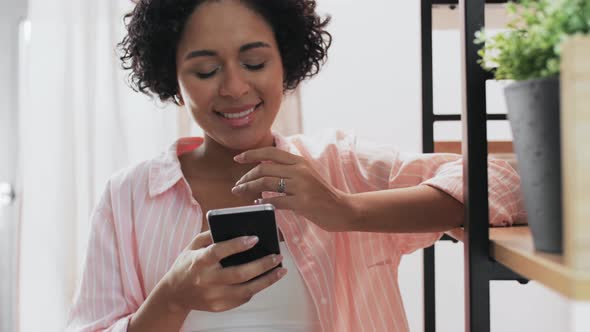 Smiling Woman with Smartphone at Home alt