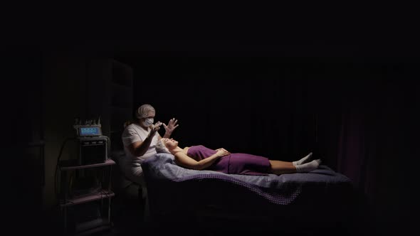 Woman Receiving Facial Massage in Spa Salon on Massage Table alt