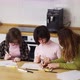 Two Girls with Down Syndrome Draw at the Kitchen Next to the Teacher or Mother Together - VideoHive Item for Sale