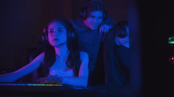 Two Beautiful Gamer Girls Playing an Online Game in the Neon Gaming Club - Their Friend Comes To alt
