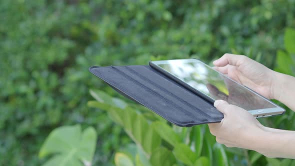 Smartphone and garden. using smartphone tablet in backyard. relaxed sitting holding smart phone.