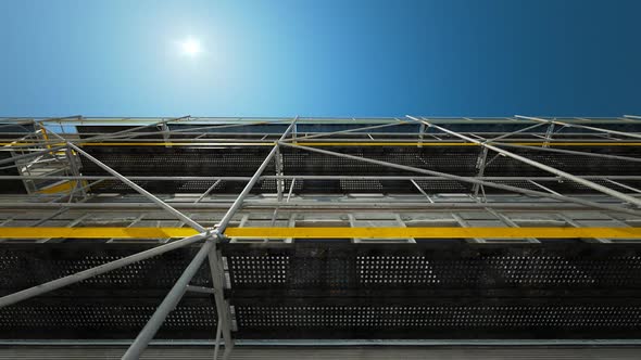 A scaffold structure connected to the facade at the construction site.