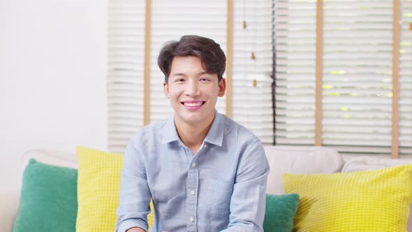 Asian handsome man looking at camera smile at home alt