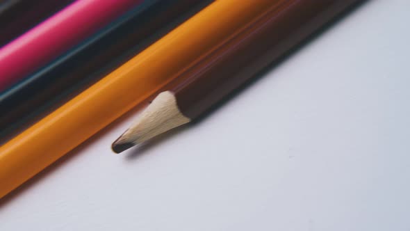 Motion Along Row of Colored Pencils on White Background alt