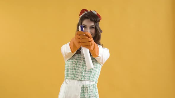 A Young Woman Presses a Button on a Window Cleaner Spray