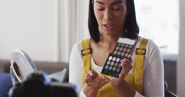 Mixed race gender fluid vlogger recording a make up vlog at home alt
