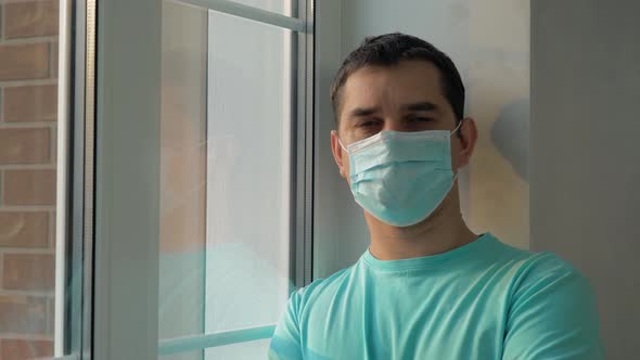 Man in a Medical Mask While at Home Isolation