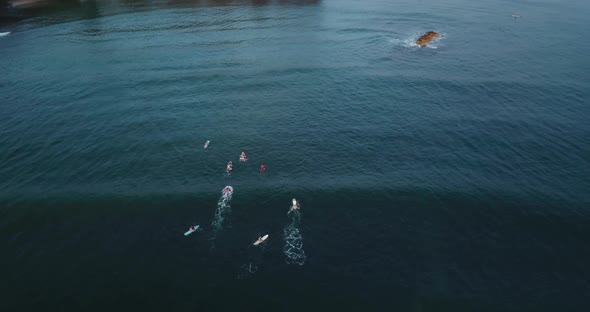 Drone shot of a beach on the North Shore of hawaii. Surfers chilling on the water waiting for waves. alt