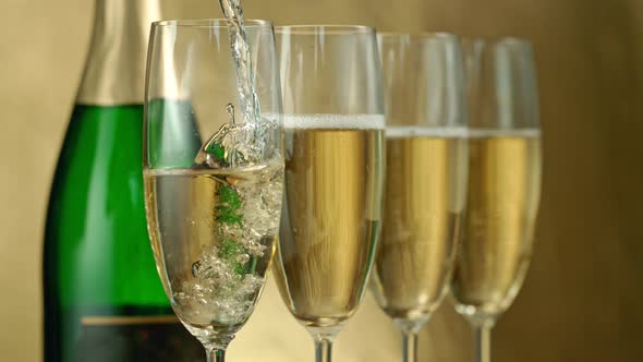 Super Slow Motion Shot of Pouring Champagne on Golden Luxury Background at 1000Fps alt