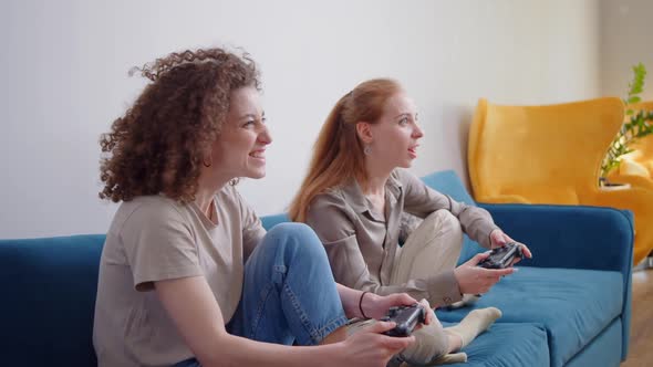 Happy Young People Playing Video Games on Console While Sitting on Couch in Front of Tv alt