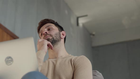 Young guy came up with an idea while sitting at work in a laptop alt