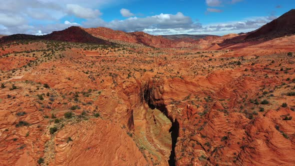 Drone flying over beautiful landscape of red rock valley. Drone slowly flying down to inside a canyo alt