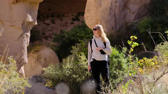 Woman Stands in Middle of Mountains and Hills and Thinks Where to Go alt