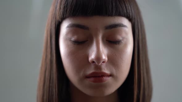 A young asian girl is looking at camera sadly. Close up shot. A beautiful gir.	 alt